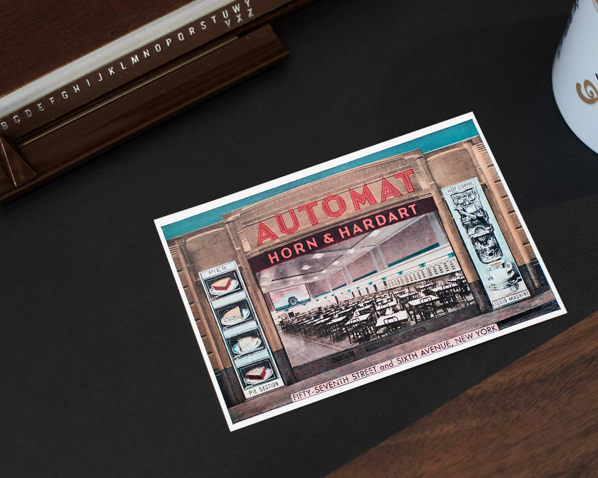 Vintage-style promotional card for Horn & Hardart Automats on a dark surface with a coffee cup.