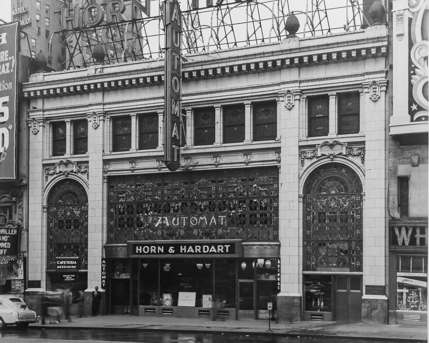 Vintage black and white photo of a large building with 'Horn & Hardart' signage.