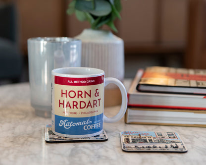 Coffee cup on a table with coasters and books.