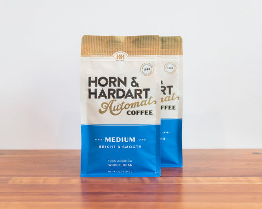 Two bags, Horn & Hardart Medium Roast Automat Coffee bag sitting on a wooden surface