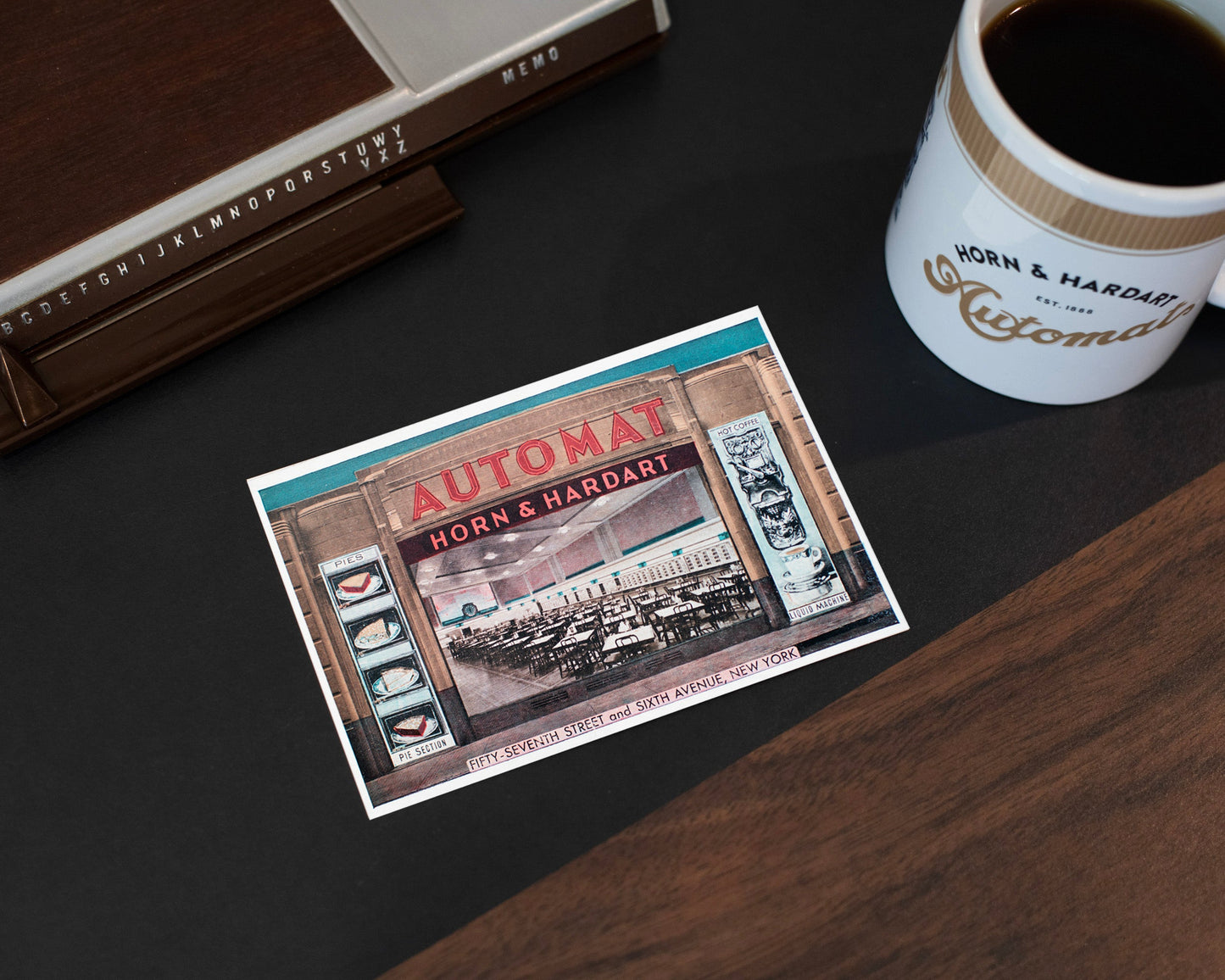 Vintage-style promotional card for Horn & Hardart Automats on a dark surface with a coffee cup.