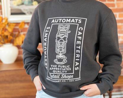 Person wearing a dark grey sweatshirt that says restaurants, automats, cafeterias, retail shops. Horn & Hardart Est 1888