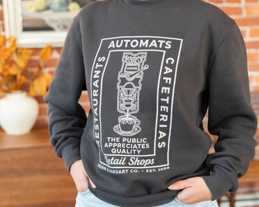 Person wearing a dark grey sweatshirt that says restaurants, automats, cafeterias, retail shops. Horn & Hardart Est 1888