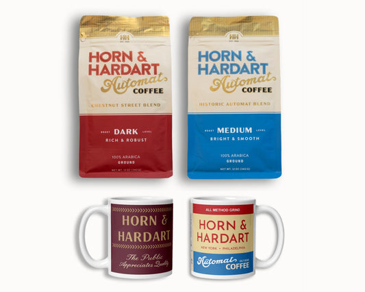 Two packages of Horn & Hardart coffee and two mugs on a white background