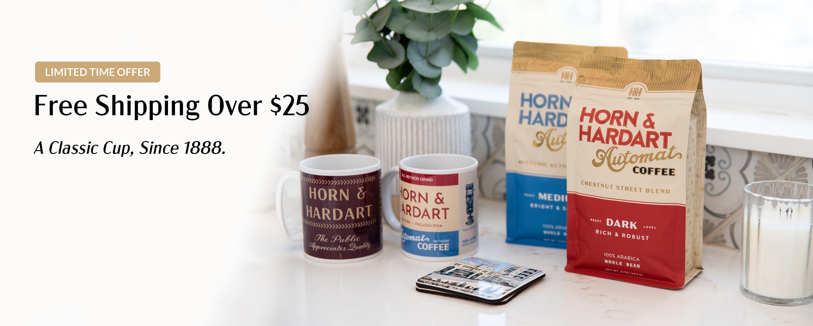 Horn & Hardart coffee products including bags and cups on a white surface with a plant in the background.
